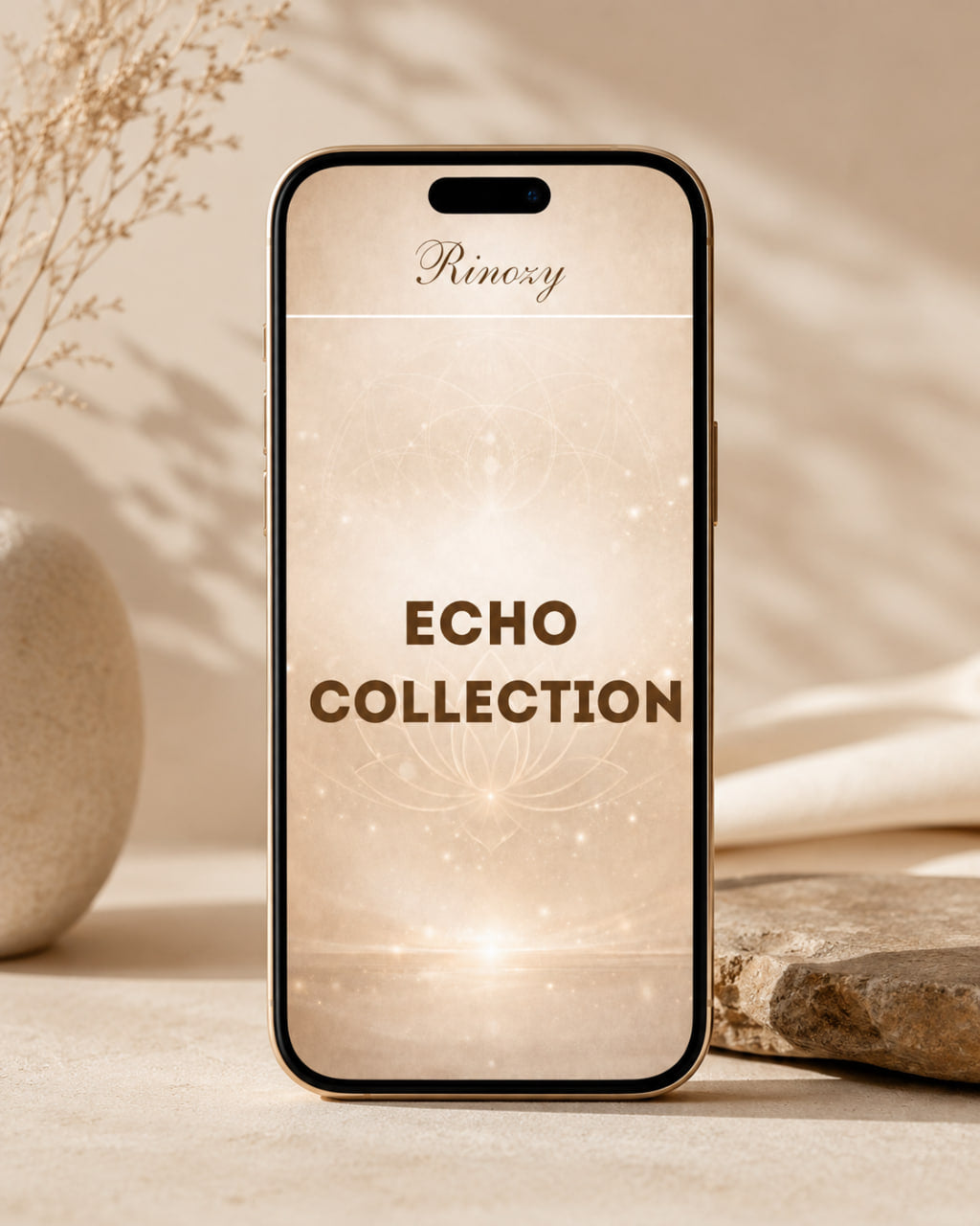 A smartphone centered on a warm beige surface with soft shadows, dried stems, and a stone prop. The phone screen displays the brand name 'Rinozy' and the text 'ECHO COLLECTION' over a soft glowing beige pattern.
